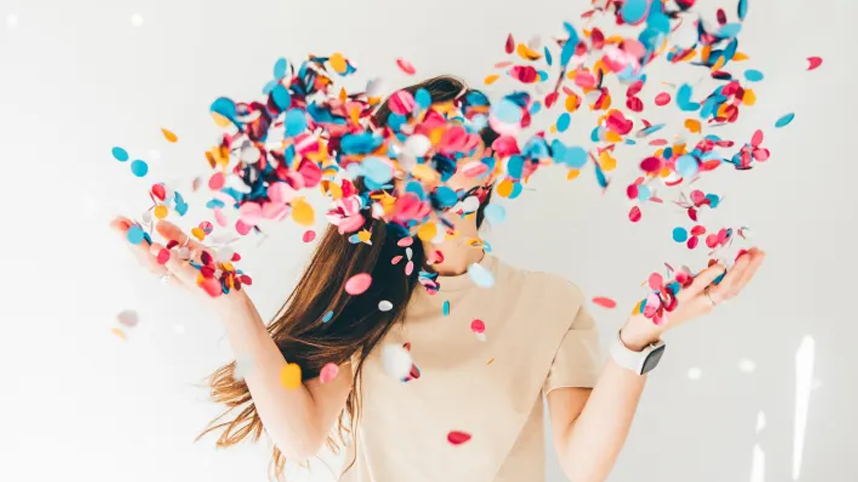 Woman with confetti flying around her