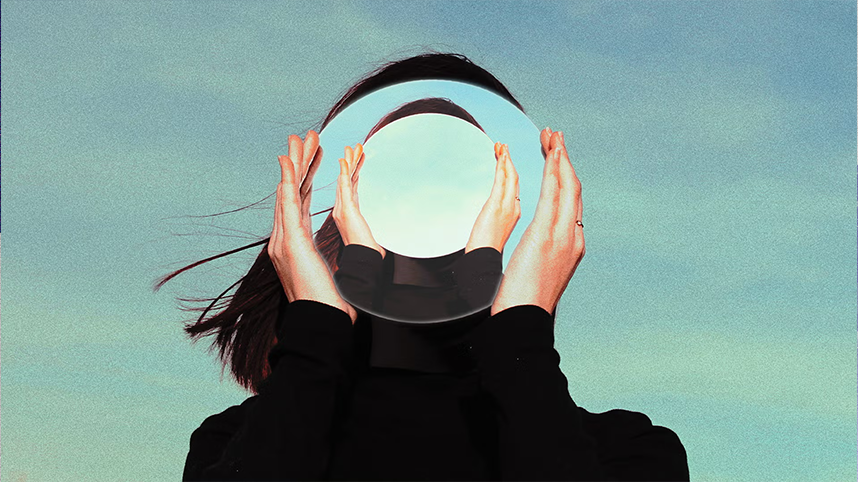 Person holding mirror over face creating distorted image