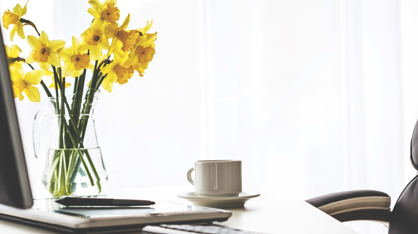 Desk with laptop flowers and coffee