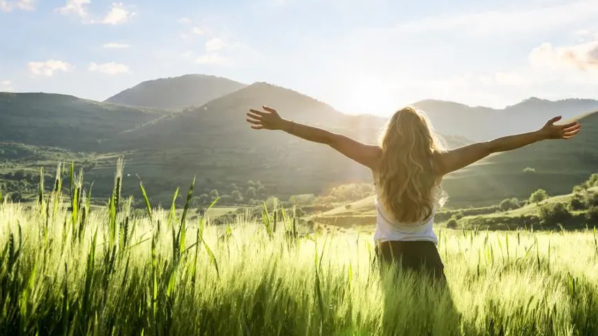 Person standing in sun lit field