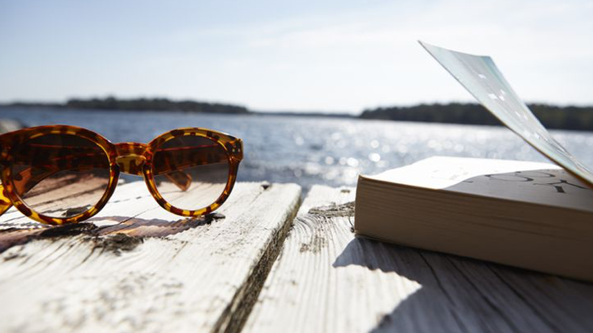 Sunglasses and book on boardwalk