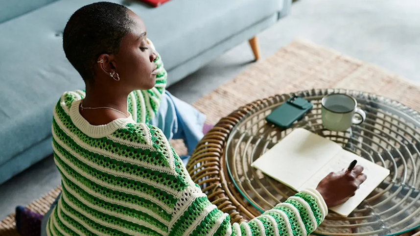 Person sitting and writing in a journal